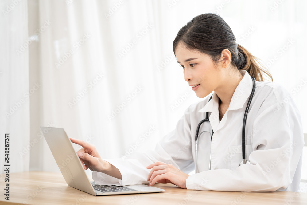 Asian female doctor using laptop computer online video call remote talking to patient. Medical practitioner giving online virtual consultation to patient from hospital office. Asian female doctor using laptop computer online video call remote talking to patient. Medical practitioner giving online virtual consultation to patient from hospital office.