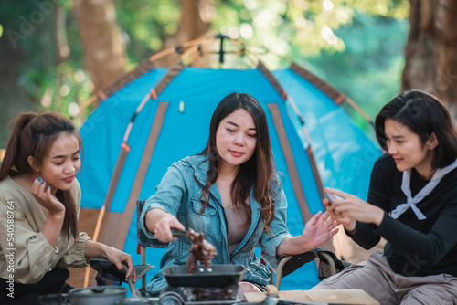 Young women cooking and use smartphone take photo on camping © Johnstocker