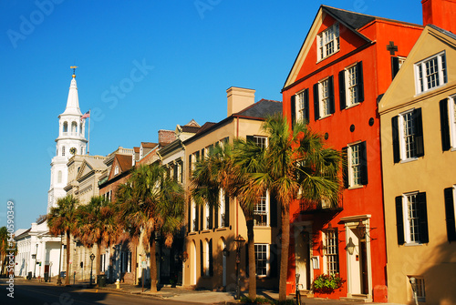 St Michaels Church stands at the end of a row of colorful homes in the downtown area of Charleston, South Carolina