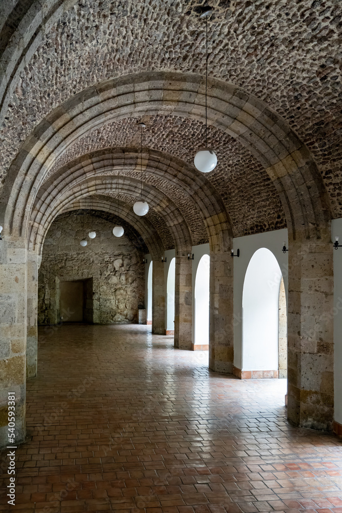 corridor with stone arcades natural light from the side, colonial architecture, mexico