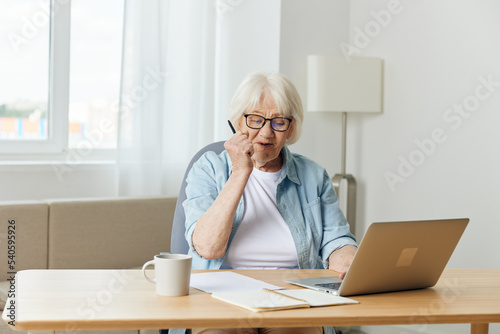 a satisfied woman happily communicates via video link via laptop during the workflow from home and actively gestures with her hand