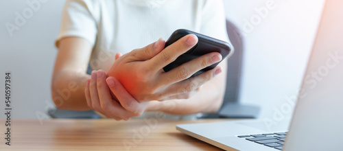 Woman having wrist pain when using mobile phone during working long time on workplace. De Quervain s tenosynovitis, ergonomic, Carpal Tunnel Syndrome or Office syndrome concept