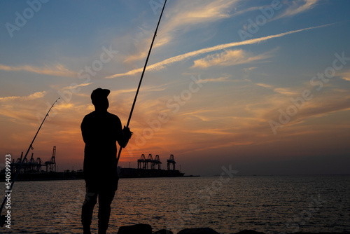 fishing on the beach at sunset