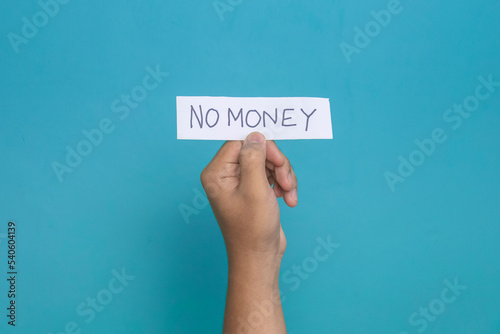 a hand holding na young man hand holding a paper reads no money sign. illustrated as a jobless or unemployed man. isolated blue backgroundo money sign photo