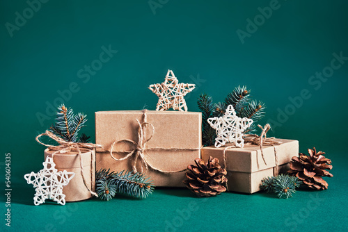 Christmas sustainable gift boxes composition with natural decor on green background. Christmas zero waste, boxing day and winter holiday