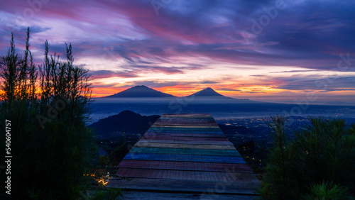 Beautiful reddish orange sunrise sky with mountain range on the garden - View from Mangli Sky View on slope  Sumbing Mountain photo