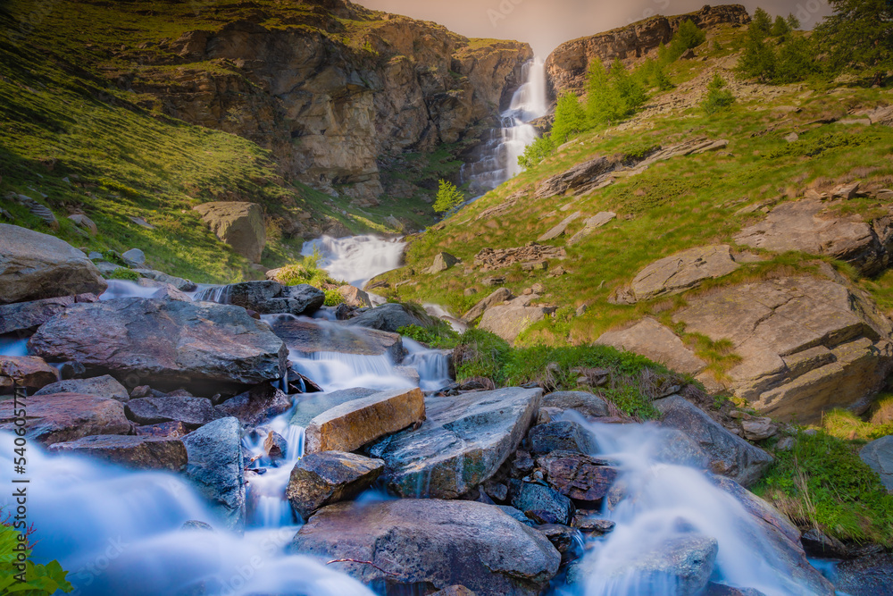 Ethereal waterfall and alpine meadows at springtime, Gran Paradiso Alps, Italy