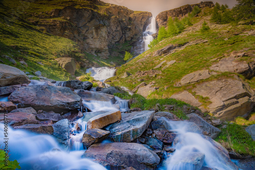 Ethereal waterfall and alpine meadows at springtime, Gran Paradiso Alps, Italy