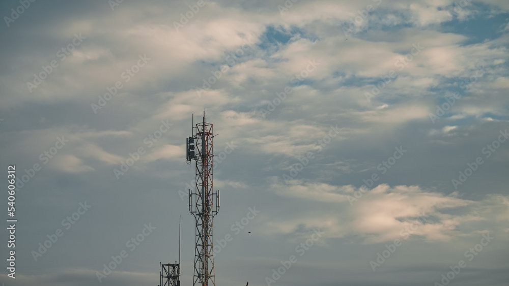 Transmitter cellular tower to strengthen and expand the network with cloudy sky background