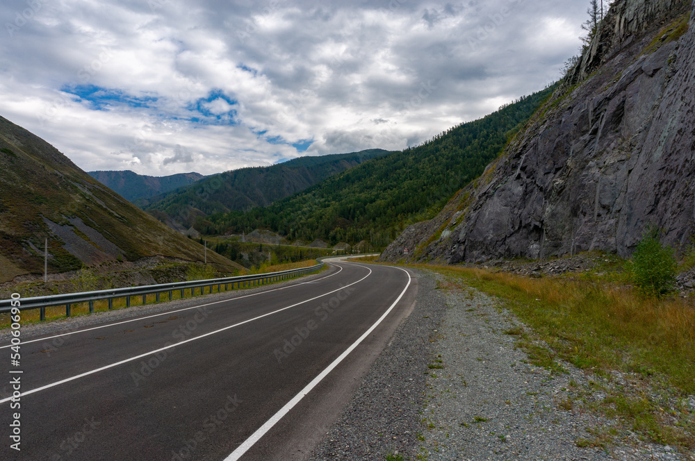 Naklejka premium A road surrounded by mountains in the Altai Republic. Gorny Altai