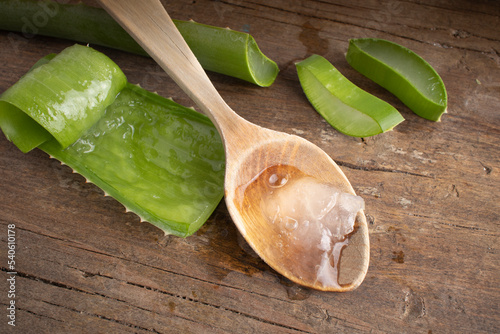 Aloe vera in a spoon on wood.