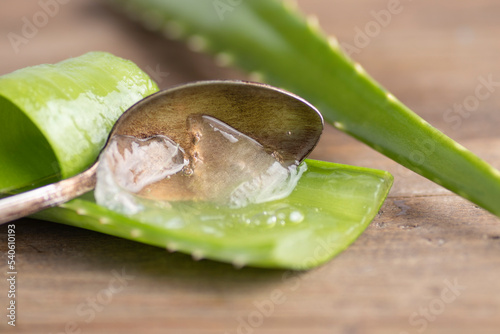 Aloe vera in a spoon on wood.