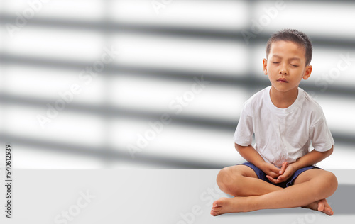 asian boy meditating on white background