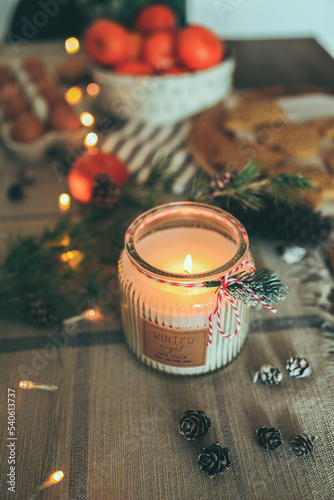 Burning candle, Christmas decor, gingerbread in a festive kitchen