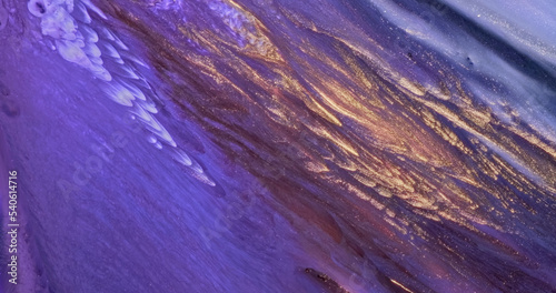 Purple gold paint. Flowing lilac color glitter paint texture. Fluid art painting abstract. Shine colorful vertical liquid flow. Luxury glamor golden background. Diagonal glow stripes pattern