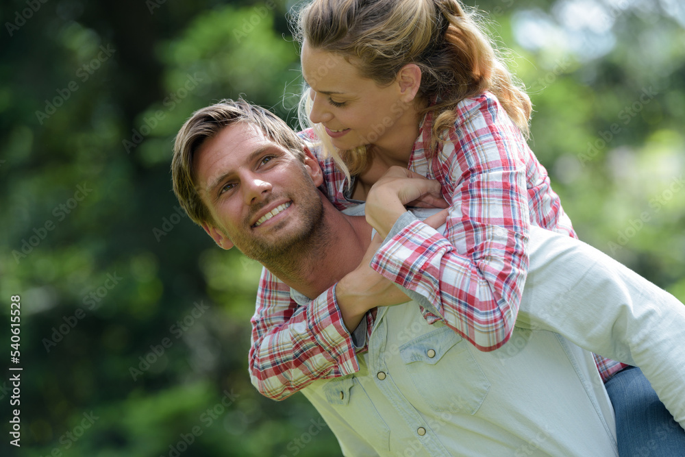 Fototapeta premium man giving his lover a piggy back