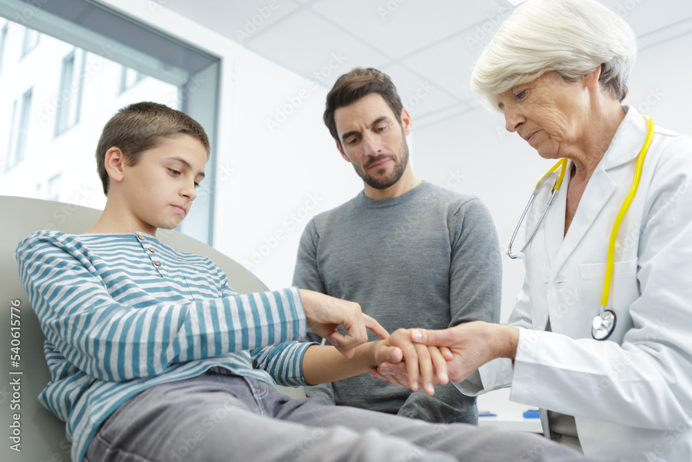 doctor examines child with a hand injury doctor examines child with a hand injury