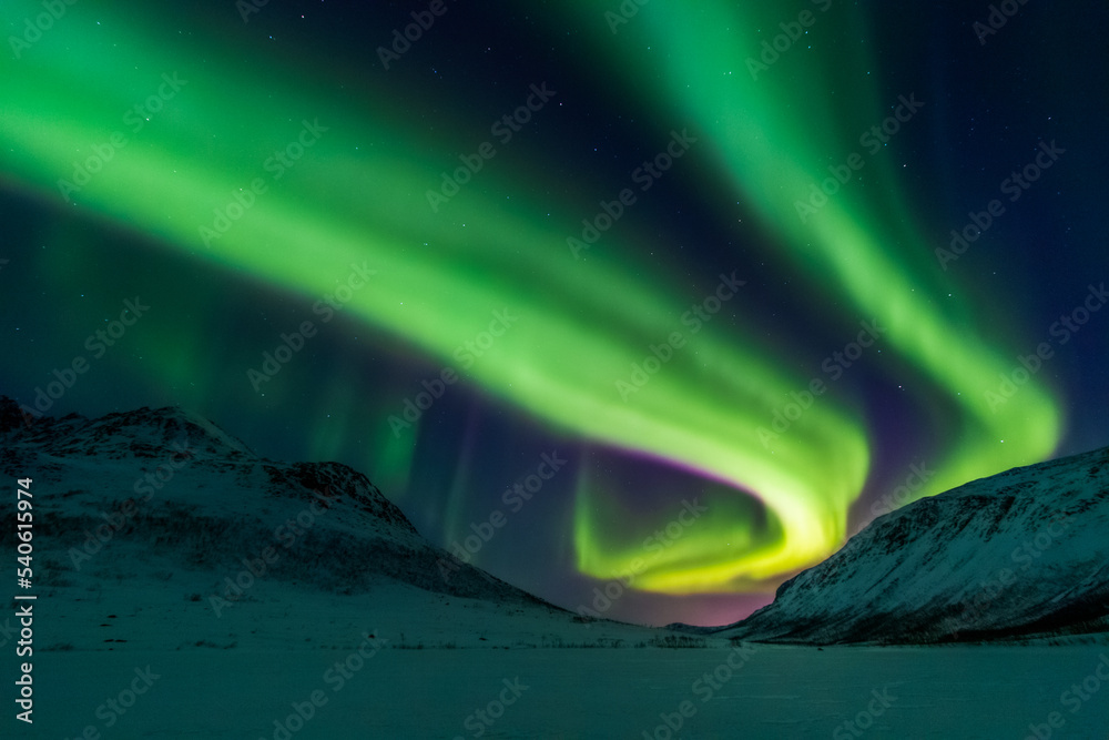 Northern lights over snowy valley
