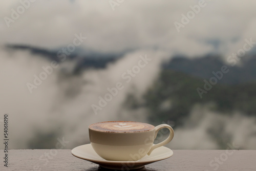 Hot coffee in white cup and blurred nature background.