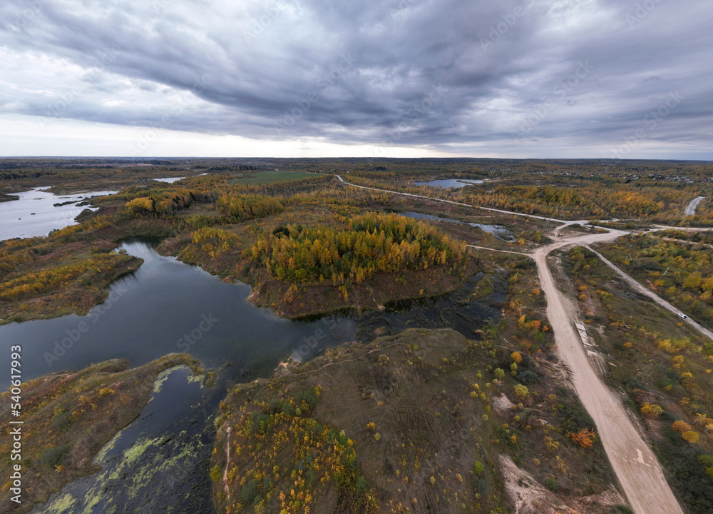panoramic view from a drone of a network of lakes and islands with a yellow forest against the backdrop of autumn colors