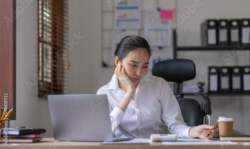 Business Asian woman using calculator and laptop for doing math finance on an office desk, tax, report, accounting, statistics, and analytical research concept