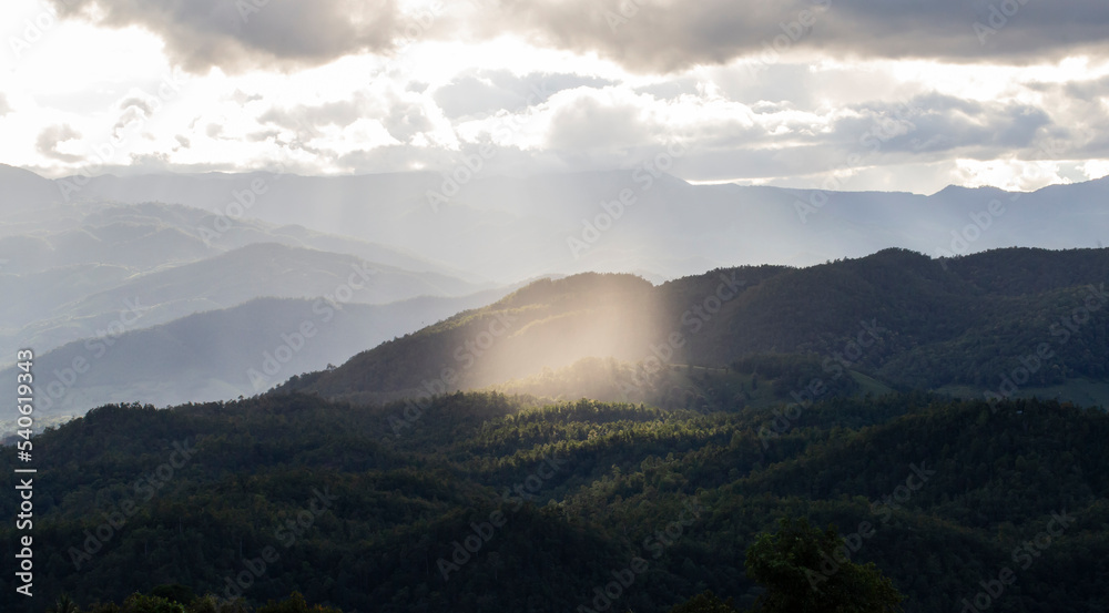 The mountains and forests were lit by sunlight in the center of the picture. The mountains and forests were lit by sunlight in the center of the picture.