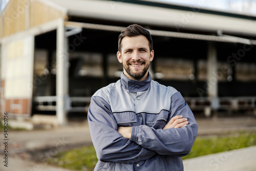 Fényképezés A happy farmer proudly stands in front of the barn outside and smiles at the camera