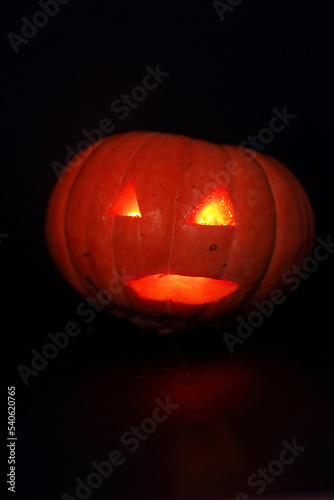 spooky concept - jack-o-lantern with burning eyes on dark background