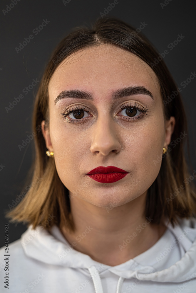 attractive fashionable young lady with mysterious brown eyes flowing hair and red lips posing. attractive fashionable young lady with mysterious brown eyes flowing hair and red lips posing.