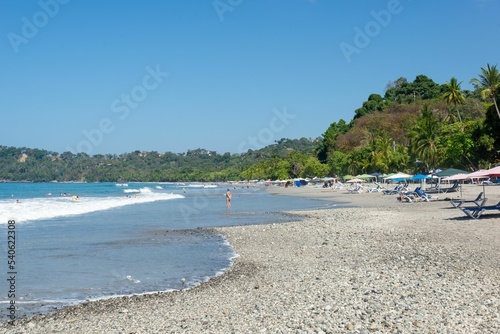 Beach chairs and vacationers enjoying the summer sun on Espadilla South Beach in Quepos, Costa Rica photo