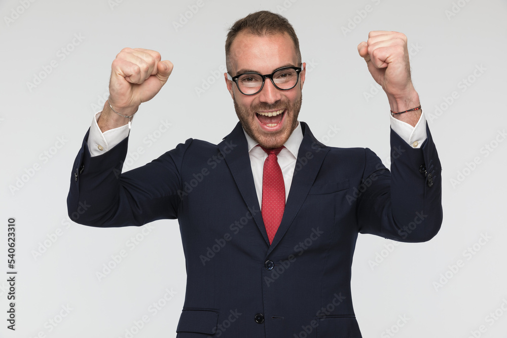 excited businessman is celebrating success with arms in the air excited businessman is celebrating success with arms in the air