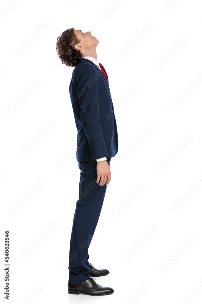 side view of curious businessman in suit standing in line and looking up side view of curious businessman in suit standing in line and looking up