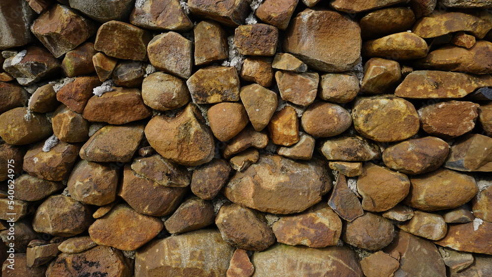 Beautiful background pattern image of a wall made of round stone red color rocks. Texture Beautiful background pattern image of a wall made of round stone red color rocks. Texture