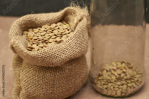 lentil grains in a canvas bag and in a glass jar on the table