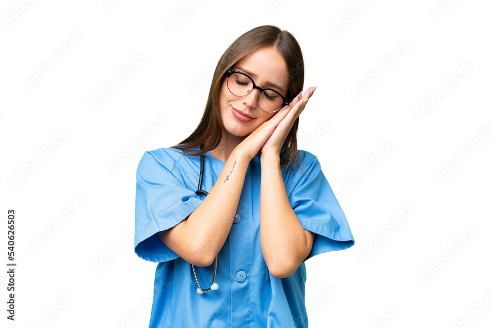 Young nurse caucasian woman over isolated background making sleep gesture in dorable expression