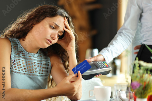 Worried customer paying expensive bill in a restaurant