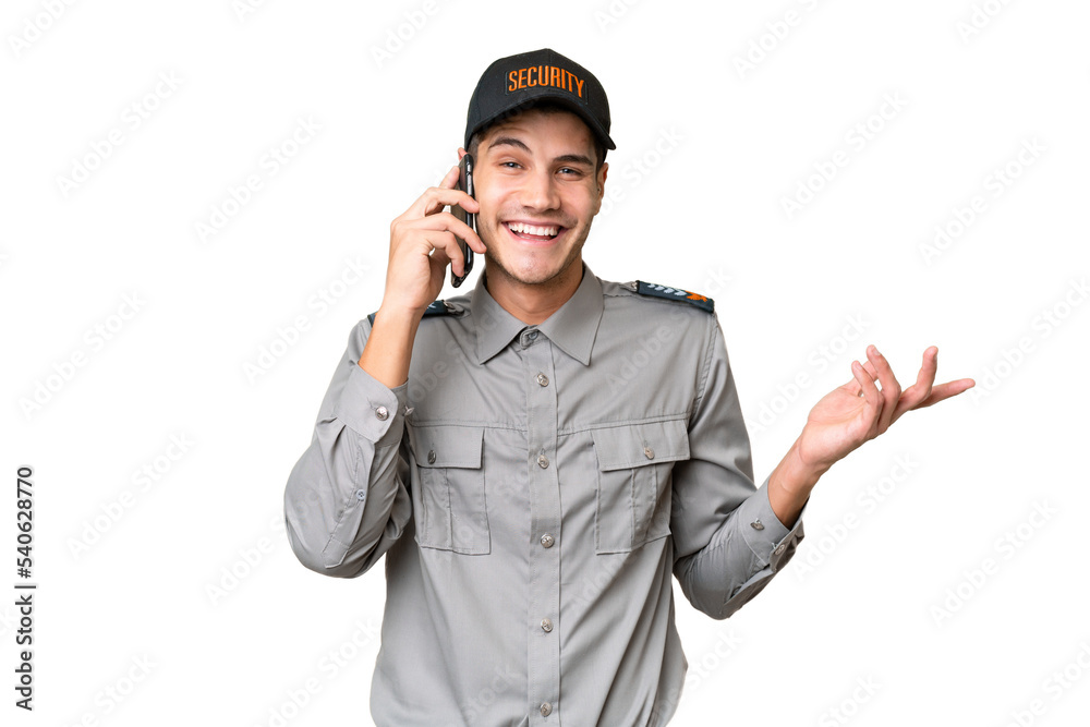 Young security man over isolated background keeping a conversation with the mobile phone with someone Young security man over isolated background keeping a conversation with the mobile phone with someone