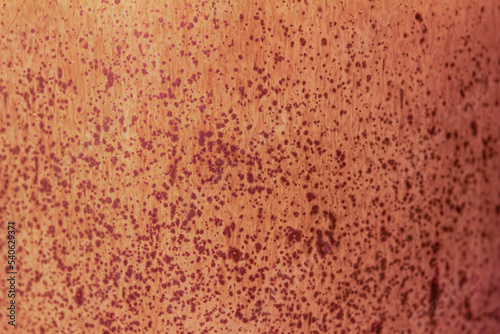 Abstract texture background of a macro photographed glazed ceramic stoneware surface in the color of reddish orange
