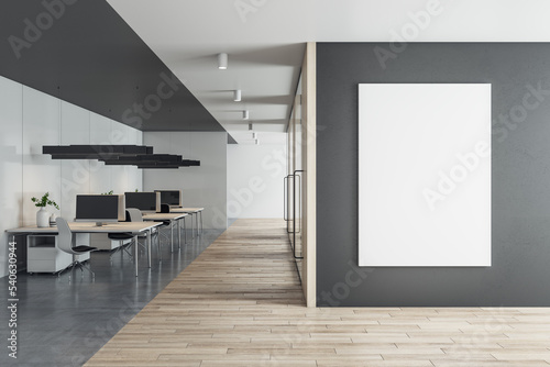 Front view on blank white poster on black wall with space for your logo or text in sunlit eco style office with stylish minimalistic work places and wooden floor. 3D rendering, mockup