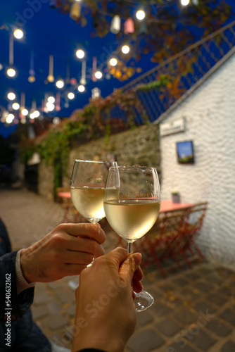 Couple drinking white wine in a restaurant on a romantic streeet with lights in Szentendre Hungary photo