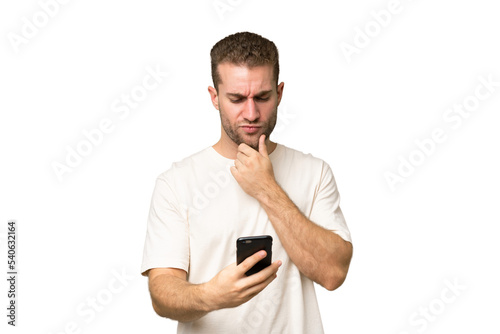 Young handsome caucasian man isolated on green chroma background thinking and sending a message