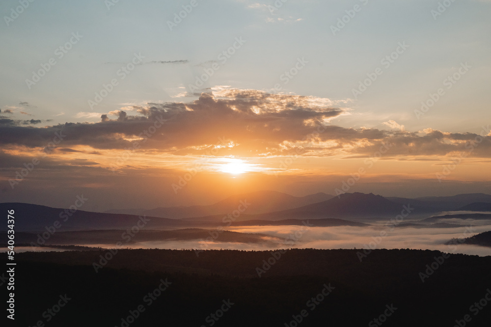 The morning sun is high over the forest, the dawn in the mountains, the beautiful landscape, the southern Urals are Russian, the fog fills the valley, the haze below.