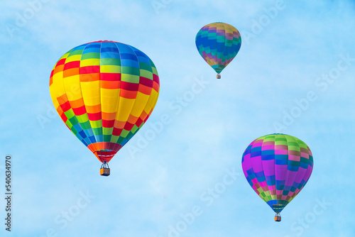 Three hot air balloons on a blue sky