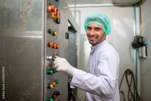 Quadro su tela worker is control operating  machine and turn on switch on the production line in the beverage factory