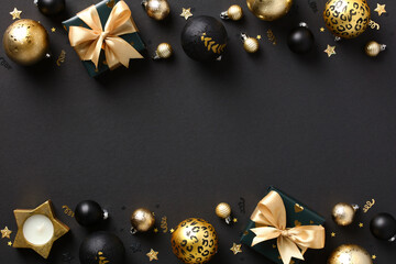 Merry Christmas and Happy New Year greeting card template. Luxury Christmas decorations and gift boxes with golden ribbon bow on black background.