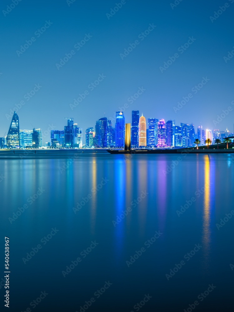 Vertical long exposure shot of Doha city skylines illuminated at night in Doha, Qatar