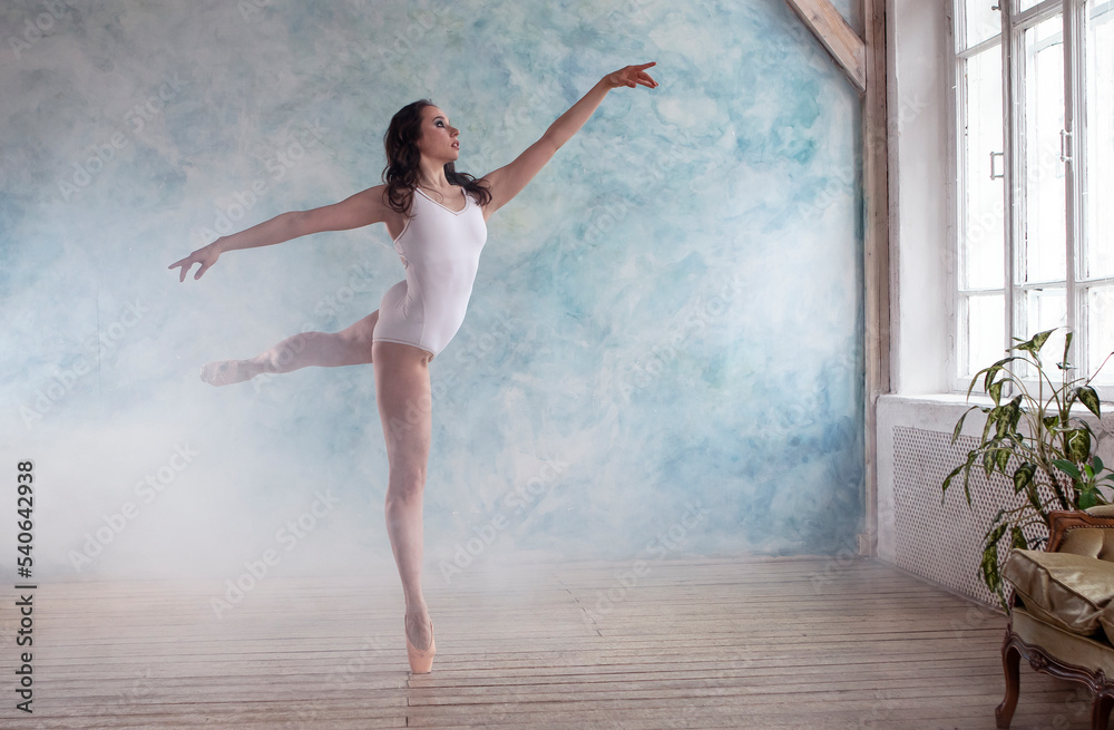a professional ballerina in a white gymnastic leotard is dancing in a room with blue walls a professional ballerina in a white gymnastic leotard is dancing in a room with blue walls