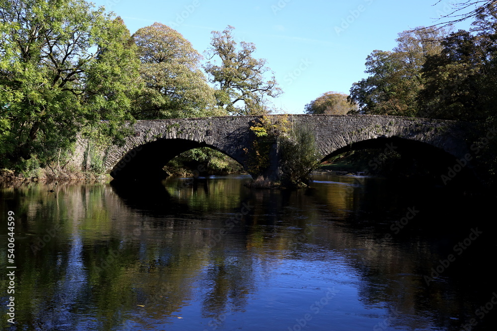 Old stone bridge carrying the A6 main road North over the River Kent in Cumbria, UK.