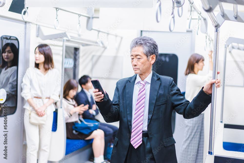 電車内でメールを送るビジネスマン 電車内でメールを送るビジネスマン