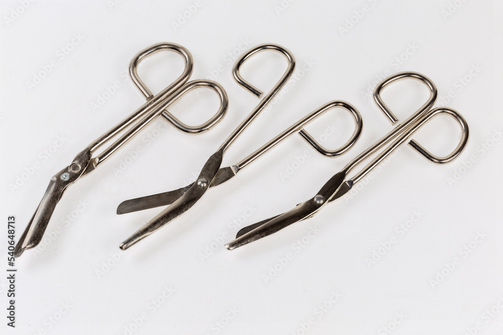 Several stainless steel trauma shears on a light surface Several stainless steel trauma shears on a light surface